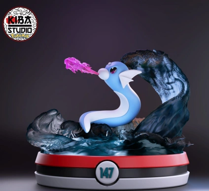 Blue serpentine Pokémon figure with white fins, pink energy effect, and rocky water-themed display base