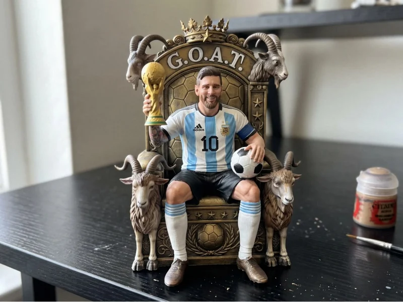 Lionel Messi football statue seated on a GOAT throne with trophy and ball